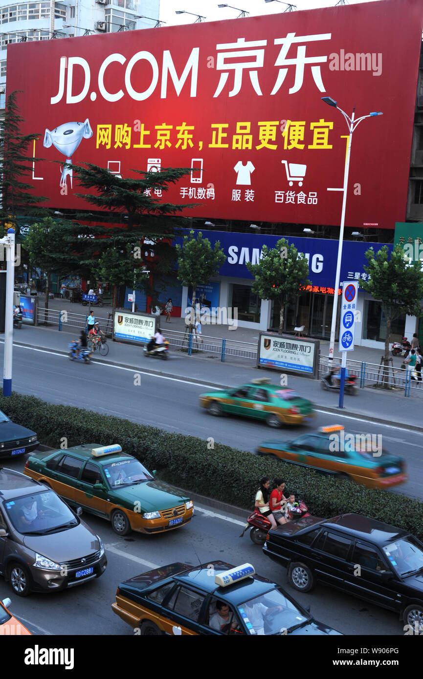 ---- Fahrzeuge fahren Sie an einer Werbung für Online shopping site JD.com, früher oder jingdong.com 360Buy.com, in Stadt Huainan, East China Stockfoto