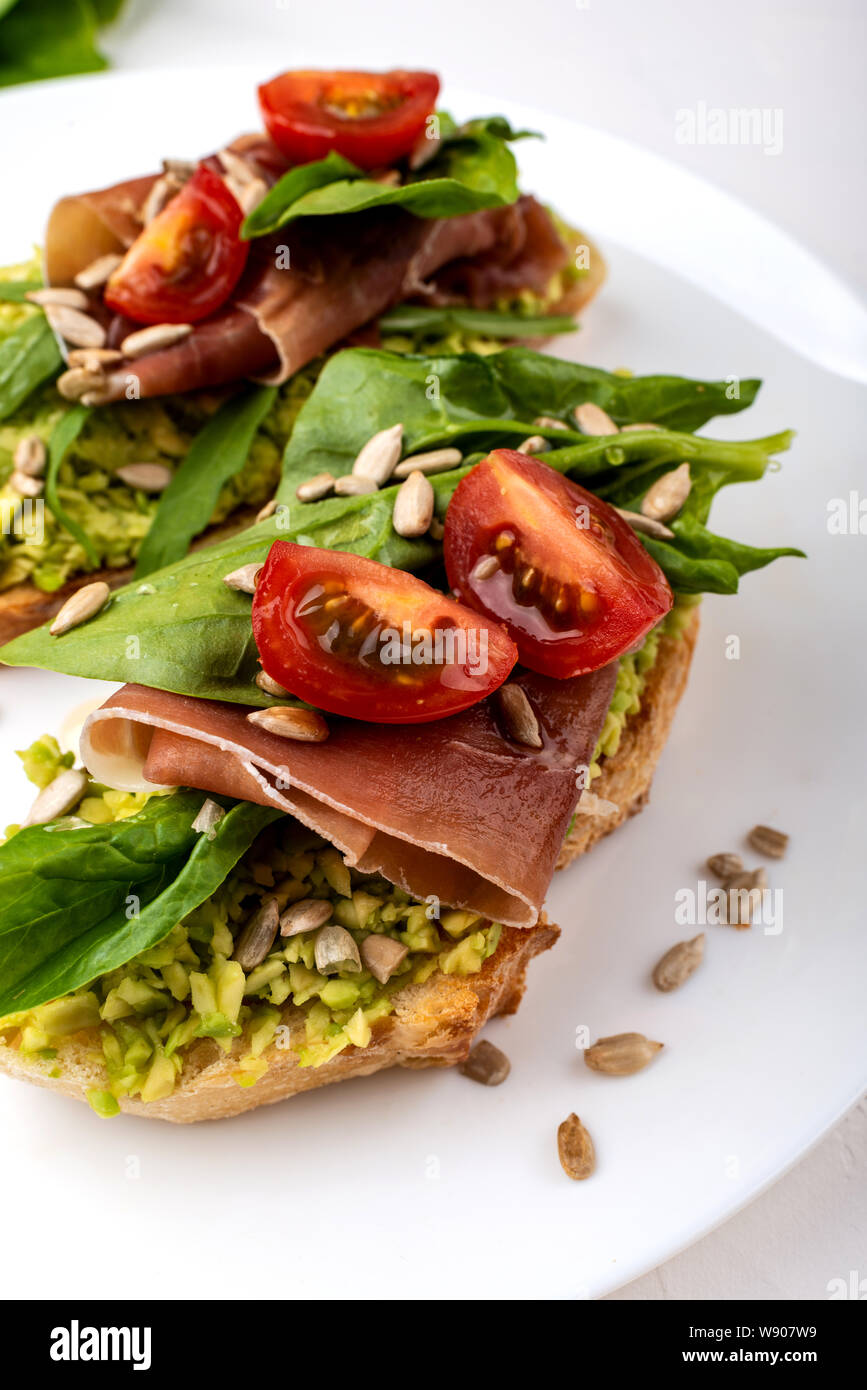 Sandwiches mit Avocado Sahne, Tomaten und Schinken. Stockfoto