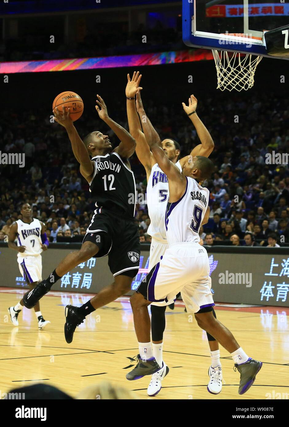 Marquis Teague von Brooklyn Nets, Links, Herausforderungen Ramon Sessions, vorne rechts, und Ryan Hollins der Sacramento Kings während eines NBA-Ausstellung Spiel in S Stockfoto