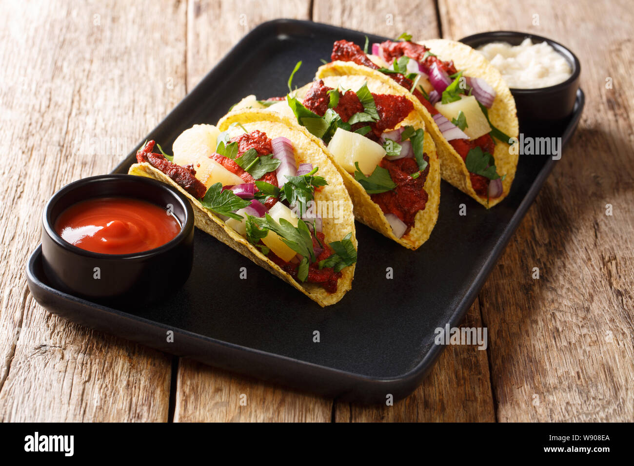 Traditionelle würzige Tacos al Pastor close-up auf einem Teller auf den Tisch. Horizontale Stockfoto