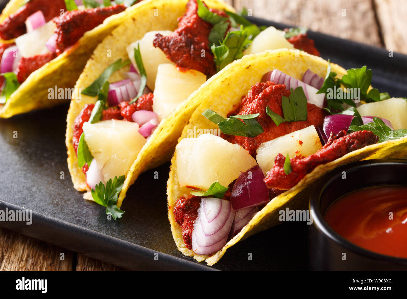 Tacos al Pastor, serviert mit Sauce closeup auf einem Teller auf den Tisch. Horizontale Stockfoto
