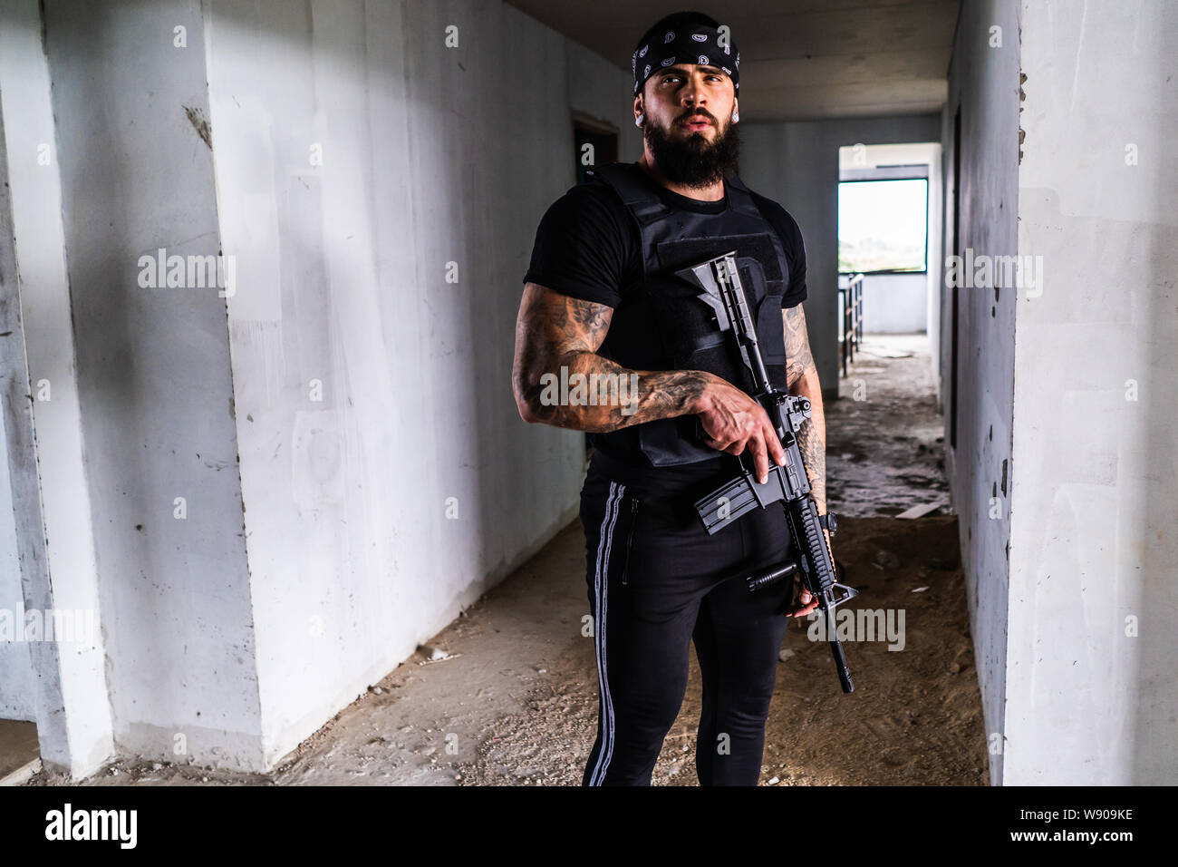 Airsoft Spielfigur mit M15-Pistole, Bandana auf dem Kopf und Tattoo Stockfoto