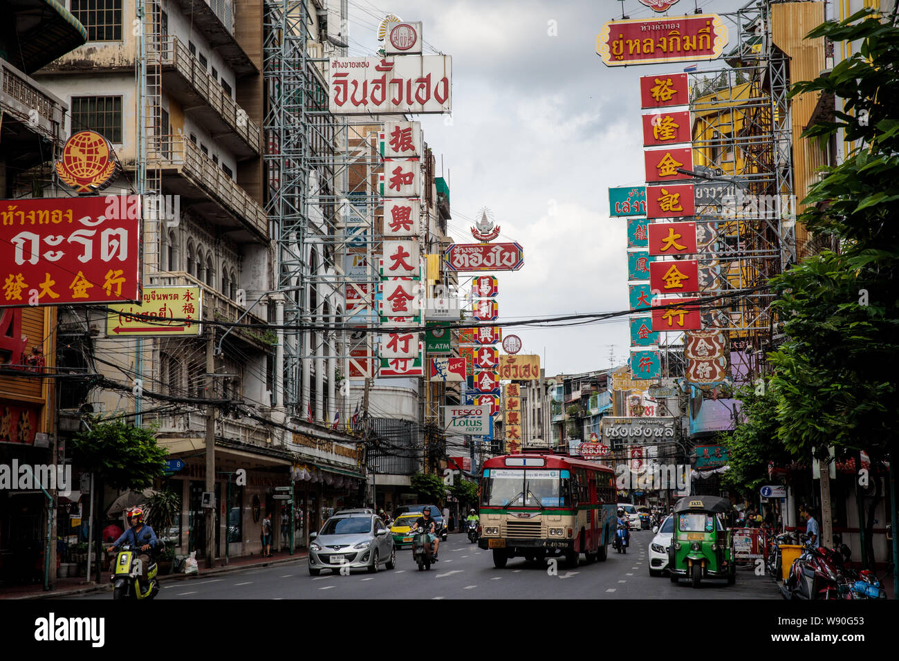 Verkehr macht seinen Weg nach unten Yaowarat Road Vergangenheit Schilder für Gaststätten und Hotels in Chinatown, Bangkok. Stockfoto