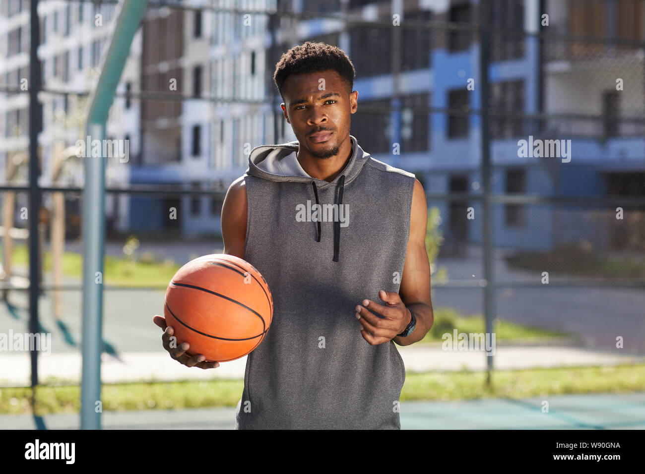 Taille bis Portrait von Afrikanischen basketball Player im Freien Gericht posiert und auf Kamera, kopieren Raum Stockfoto