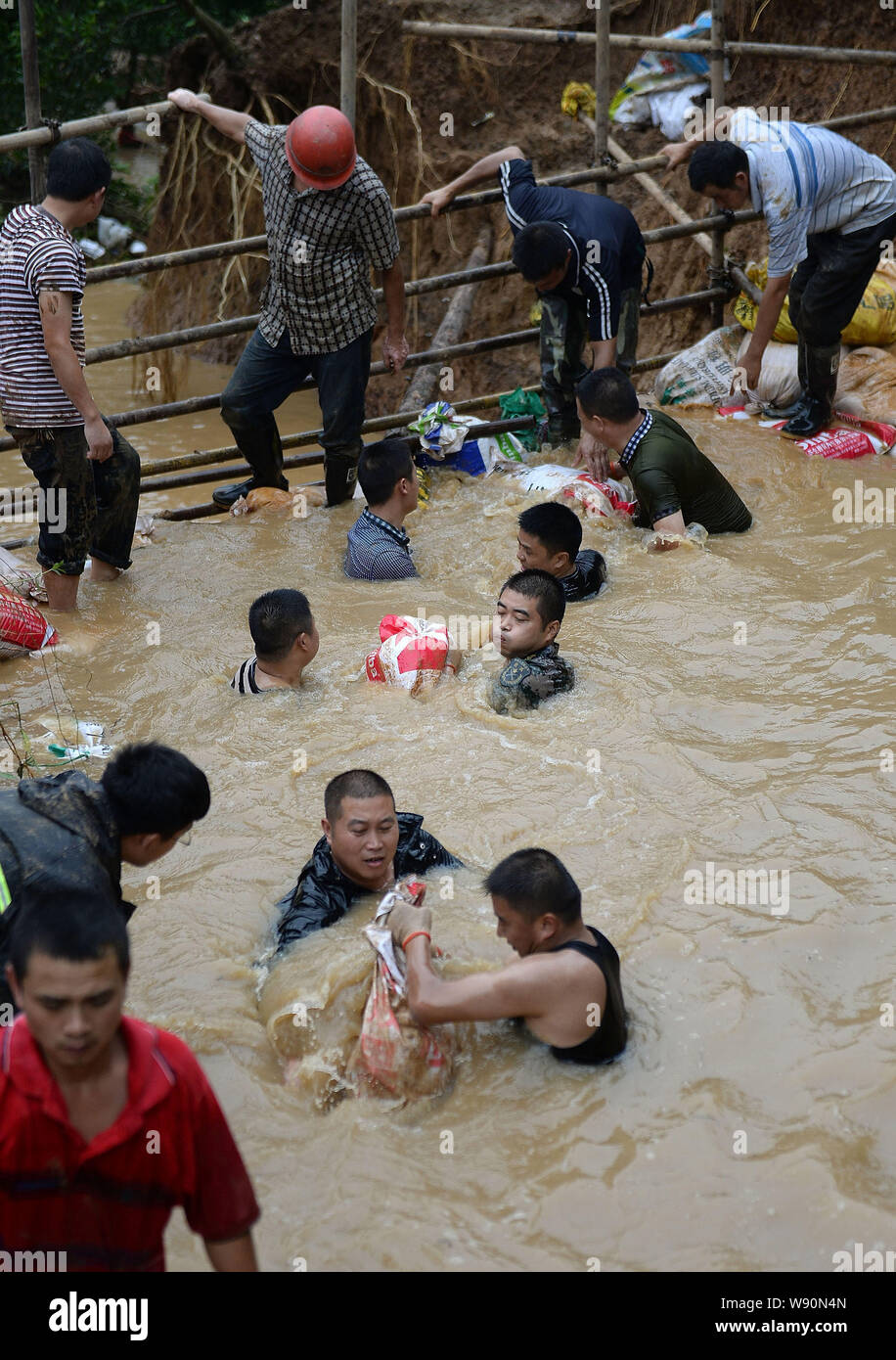 Rettungskräfte tragen Sandsäcke in schlammigen Wasser der Verletzung in Chengdu City zu blockieren, der Südwesten Chinas Provinz Sichuan, 9. Juli 2014. Rettungskräfte Stockfoto