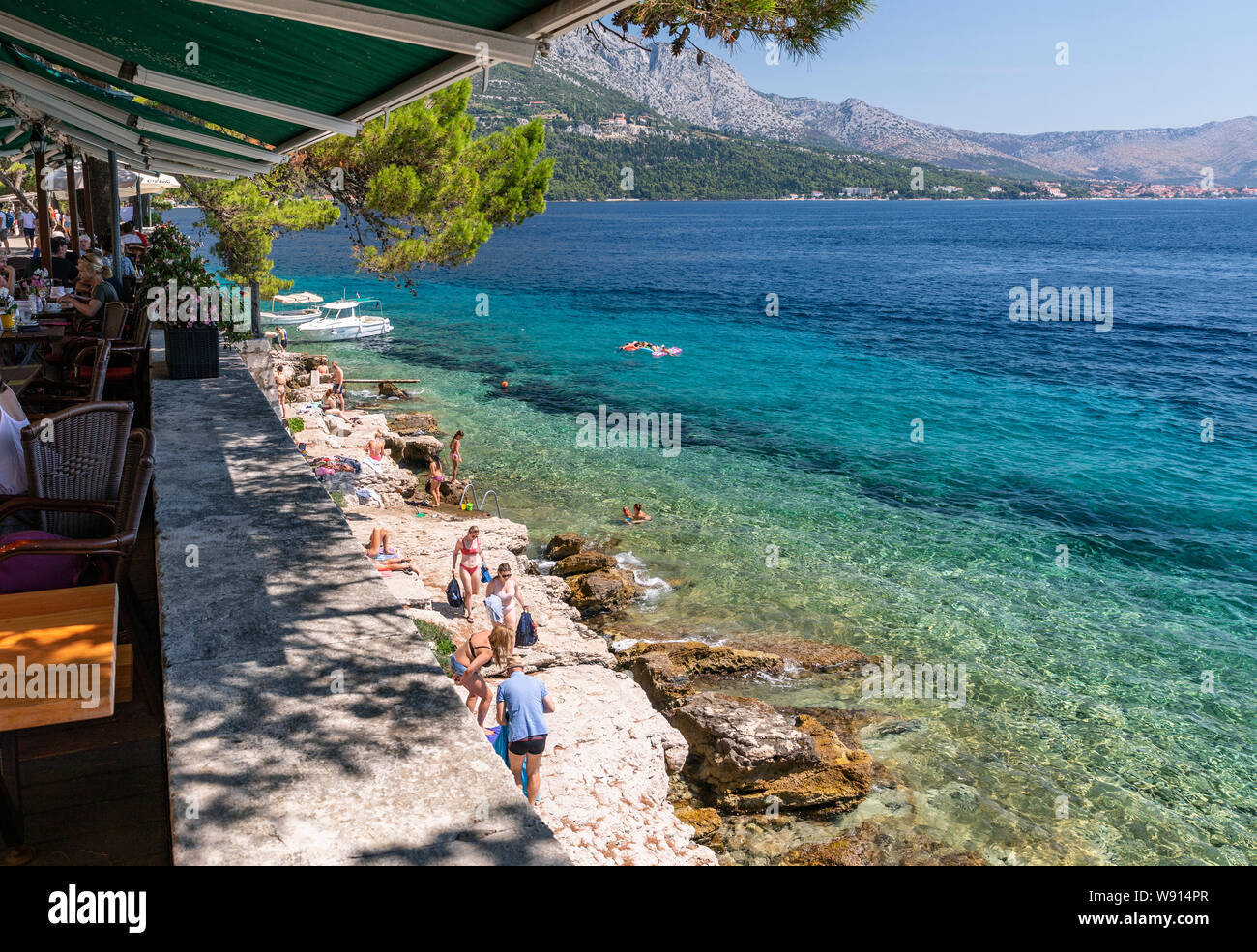 Restaurants auf den Mauern der Altstadt von Korcula und der Strand unter den Mauern Stockfoto