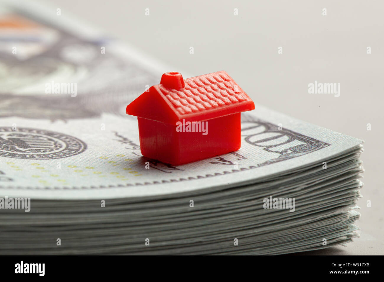 Rotes Haus auf einem Stapel Geld. Das Konzept von Steuern oder Immobilien Darlehen. Stockfoto