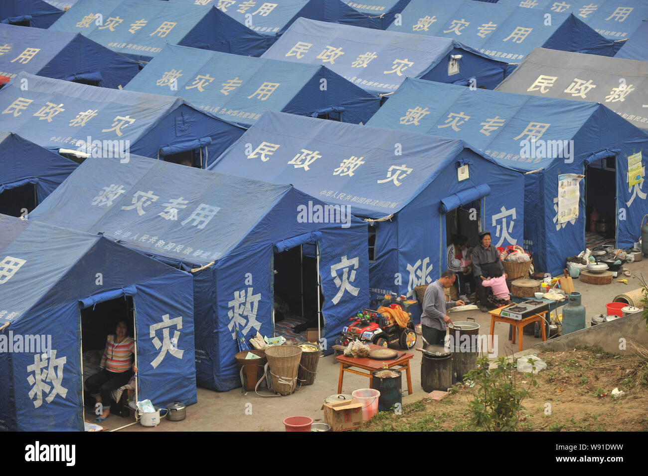 Lokale Leute kochen vor Zelte an einer mittleren Schule in der Nähe von dem Erdbeben in Longmen Stadt, Lushan County, YaAn Stadt, im Südwesten von China Sic Stockfoto