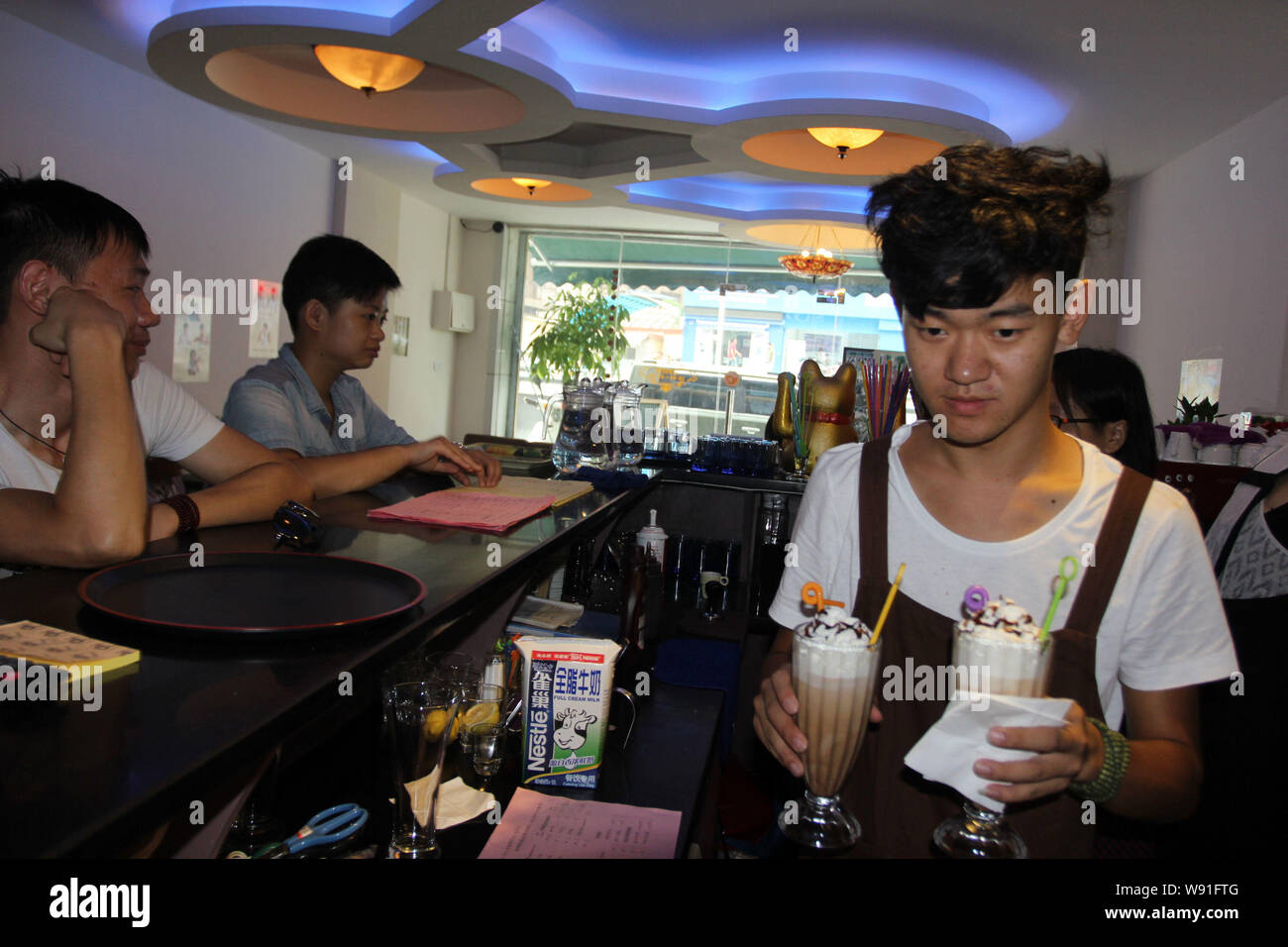 Wen Feng, einer der drei Eigentümer serviert Kaffee an der Taube House Cafe in Wuhan, China, Provinz Hubei, 25. August 2013. Drei junge gehörlose Pe Stockfoto