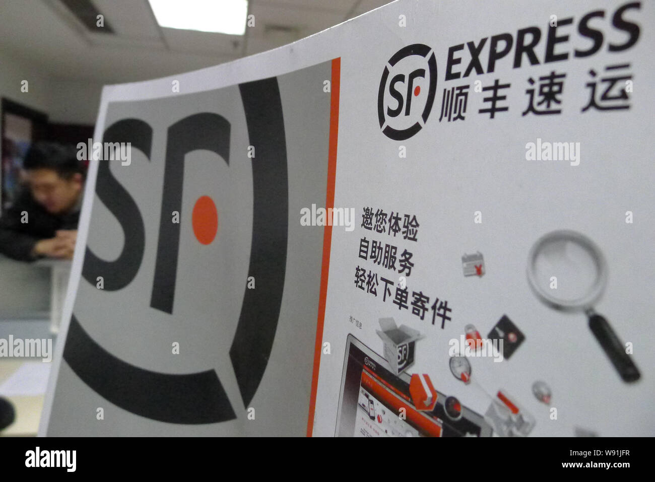 ---- Ein chinesischer Mitarbeiter Express Envelope in einer Filiale der SF Express in Qingdao Stadt, East China Provinz Shandong, den 2. Januar 2013. Chine Stockfoto