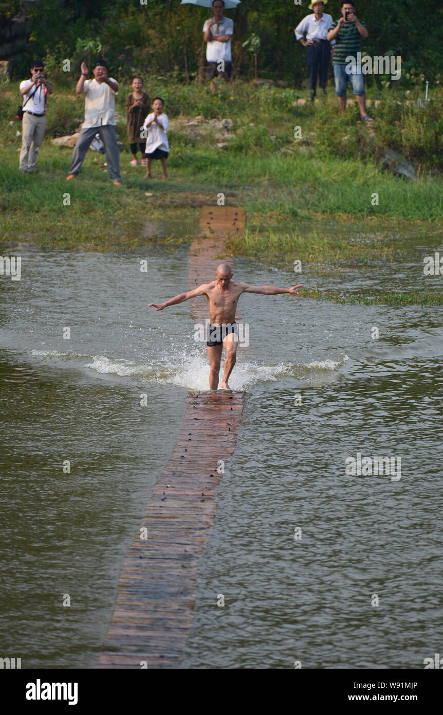 Chinesischen Shaolin Mönch Shi Liliang Spaziergänge auf dem Wasser während einer Übung in Quanzhou, südost China Fujian Provinz, 11. August 2013. Shi Liliang, kun Stockfoto