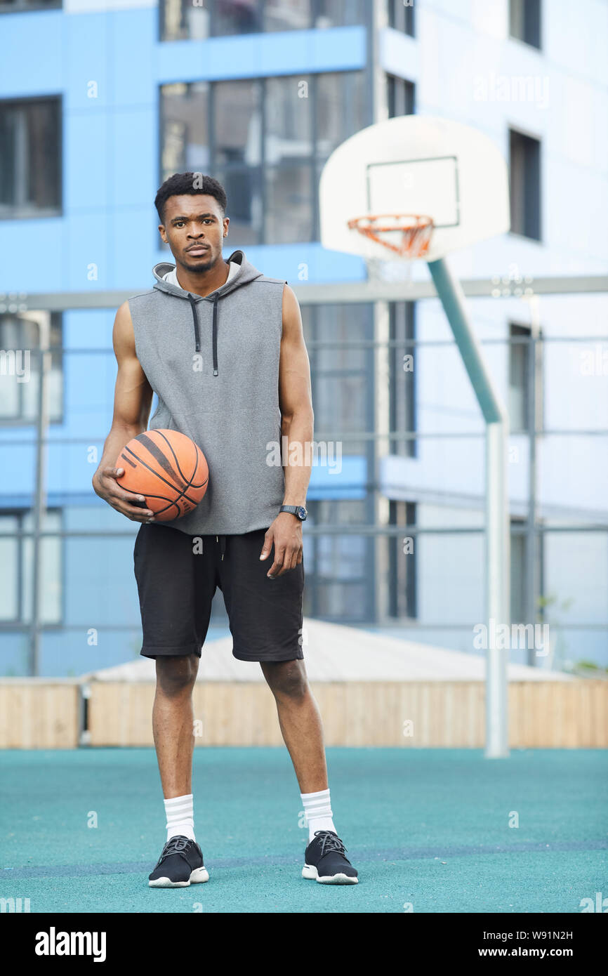 In voller Länge Porträt der Afrikanischen basketball Player im Freien Gericht posing Stockfoto