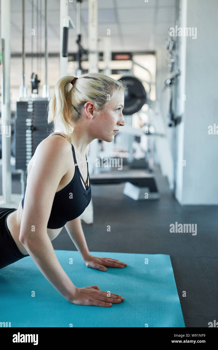 Junge Frau, ist eine Yoga Übung oder Streckung des Körpers auf der Yogamatte Stockfoto