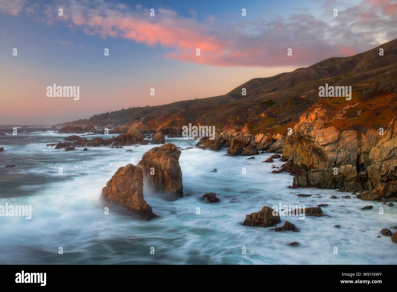Sonnenaufgang und Wellen entlang der zerklüfteten Küste von Big Sur in Kalifornien, Monterey County, Kalifornien Stockfoto