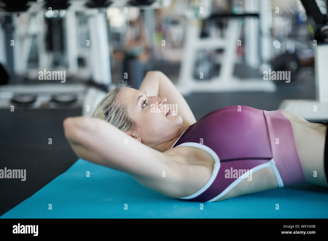 Junge Frau in Fitnesscenter Yoga Matte crunches machen wie Bauchmuskeltraining Stockfoto