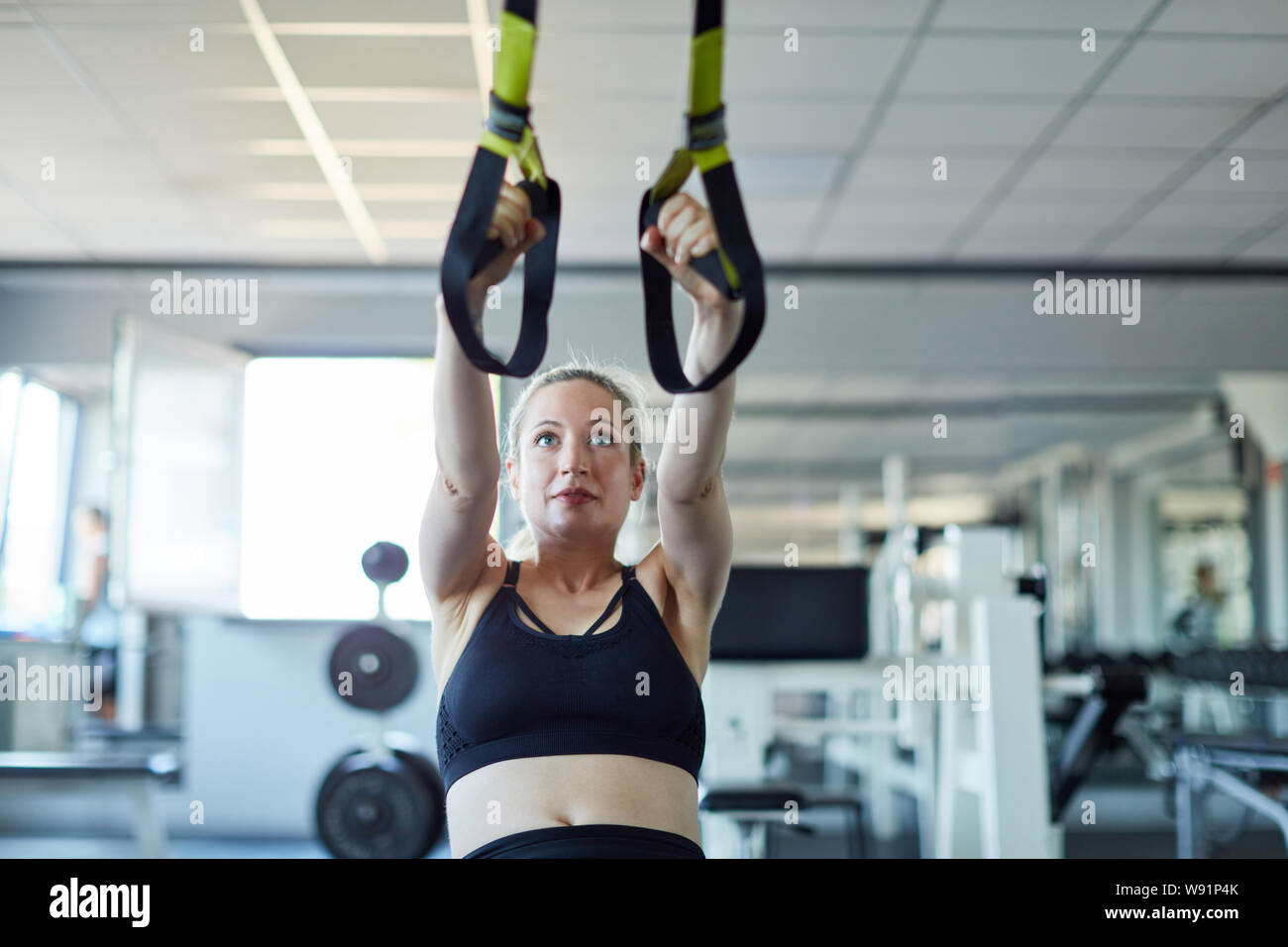 Junge Frau in Suspension oder Schlinge training für den gesunden Rücken Stockfoto