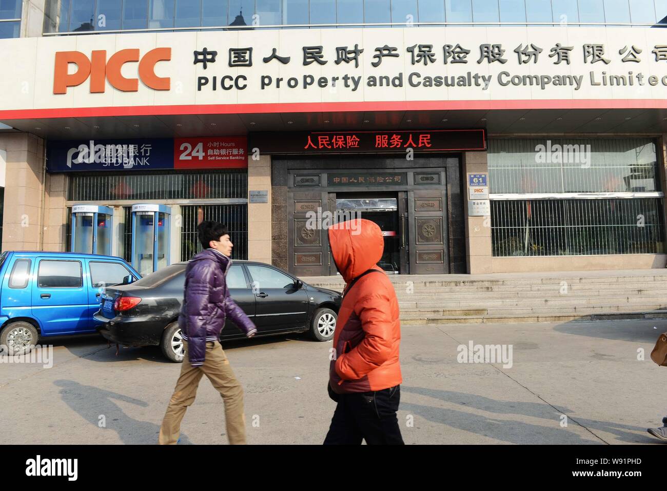 ---- Fußgänger vorbei ein Zweig der PICC in der Schaden- und Unfallversicherung Company Limited in Qingdao Stadt, East China Provinz Shandong, 7. Dezember 2012. Stockfoto