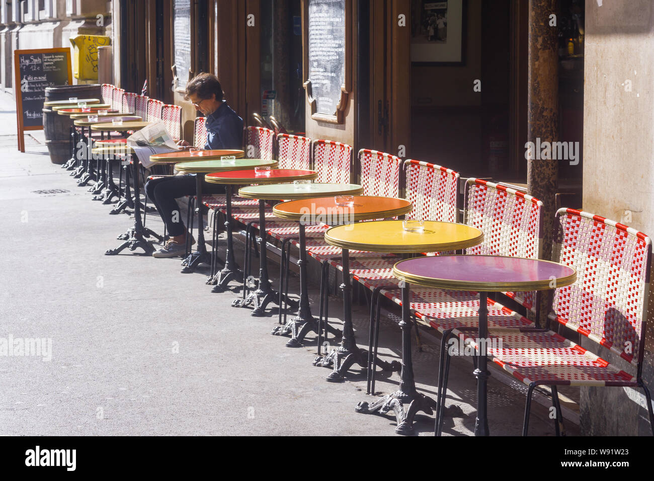 Café Paris - Pariser Mann Lesen von Tageszeitungen in einem Cafe im 10. Arrondissement, Frankreich, Europa. Stockfoto