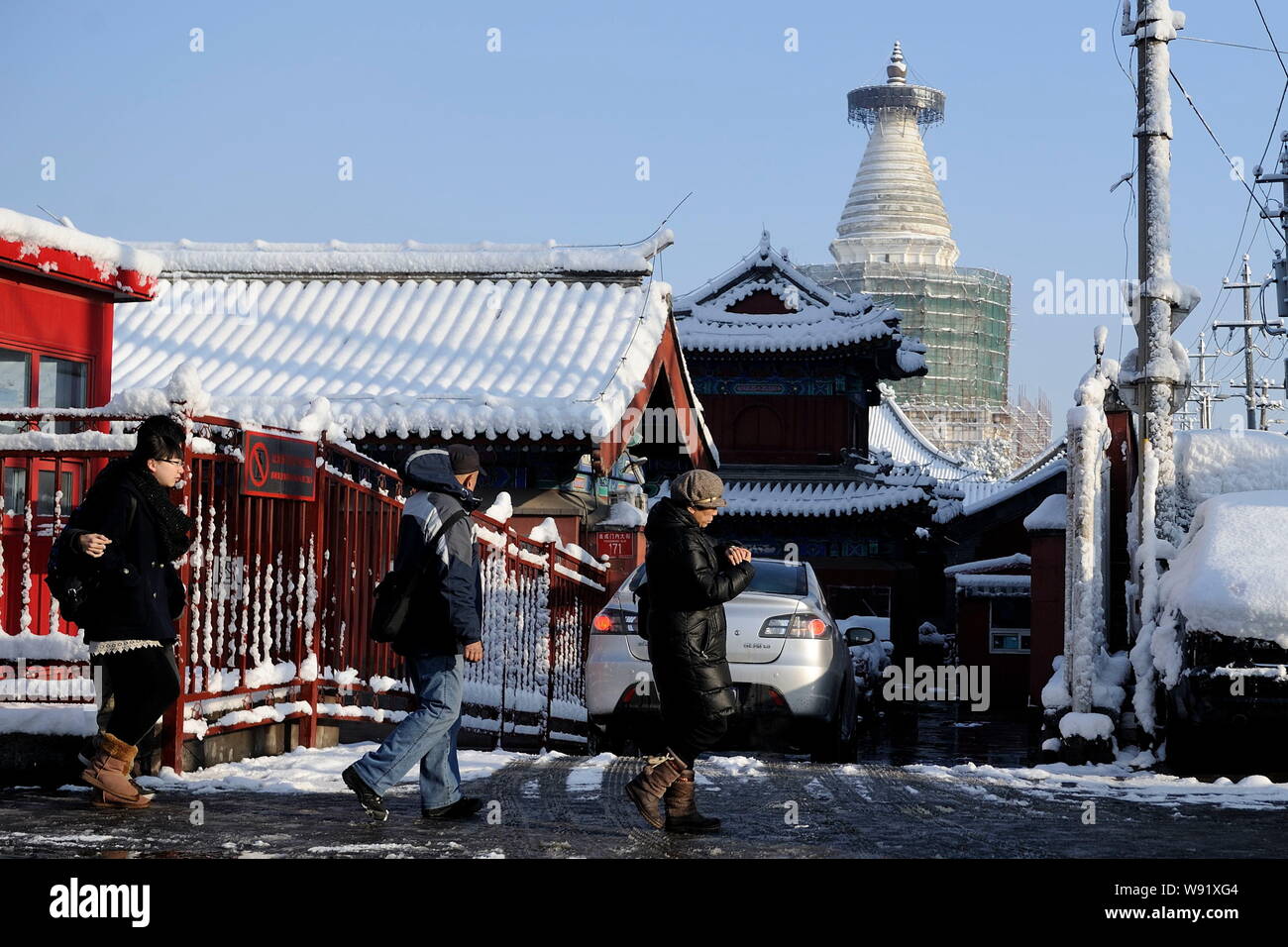 Fußgänger zu Fuß an einer Straße, die im Schnee in Peking, China, 20. März 2013. Peking Bewohner wachte gestern (20. März 2013) Die c zu finden Stockfoto