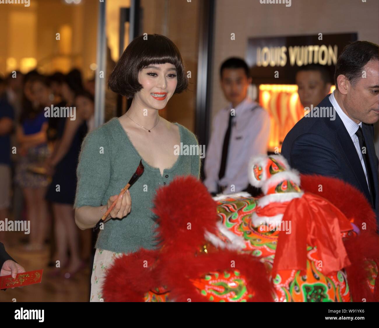 Chinesische Schauspielerin Fan Bingbing malt die Augen einer tanzenden Löwen bei der Eröffnung eines neuen Louis Vuitton store in Shenyang im Nordosten Chinas Stockfoto