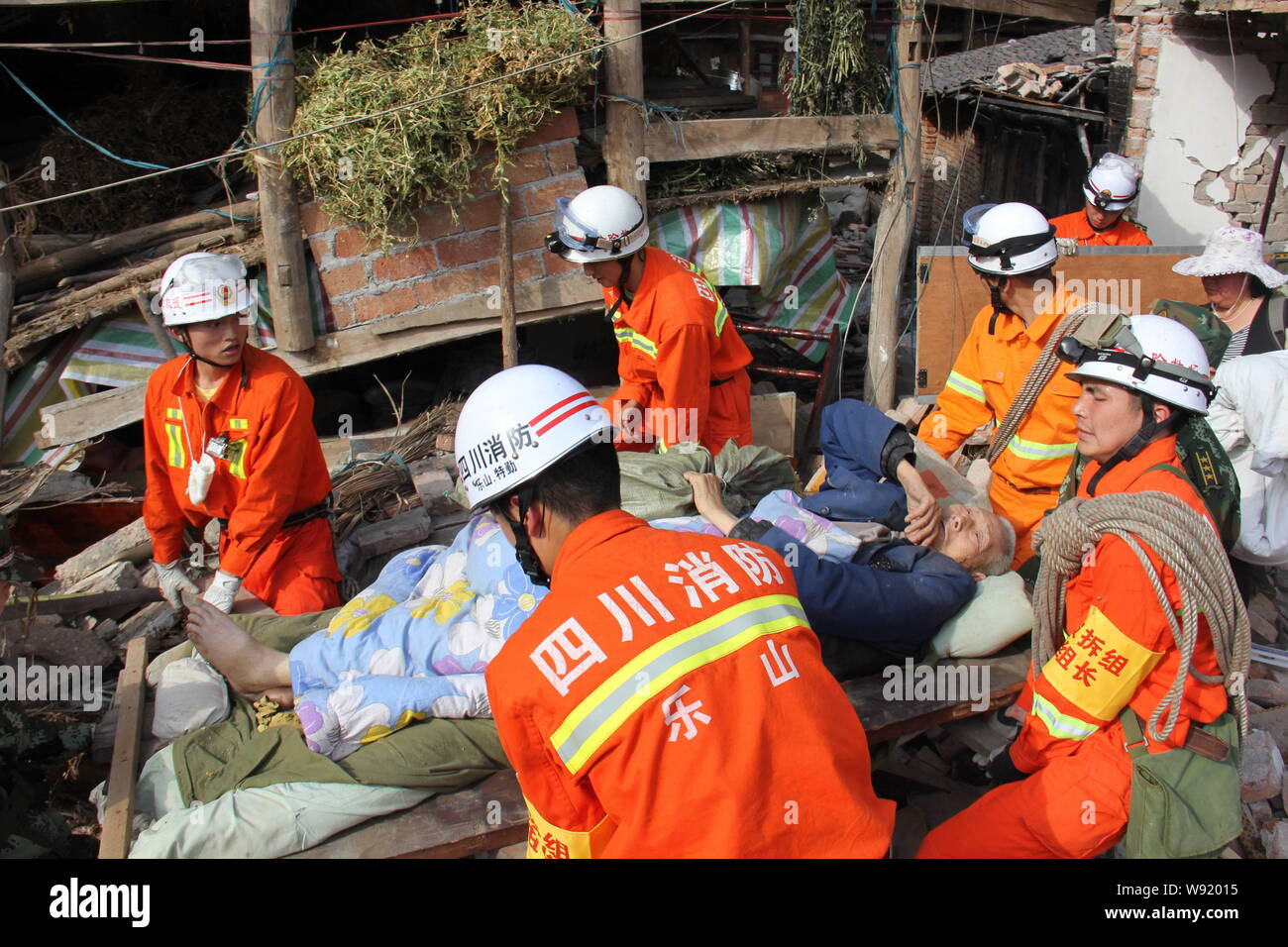 Feuerwehr Rettung einen Gelähmten alten Mann aus einem bei dem Erdbeben in Lushan county Ruine, YaAn Stadt, im Südwesten Chinas Provinz Sichuan, 20. April 2013. Stockfoto