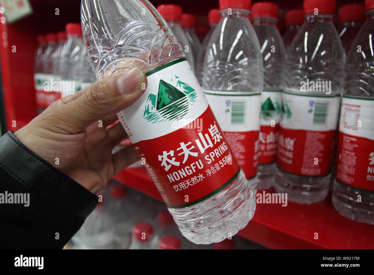 ---- Ein chinesischer Kunde kauft Flaschen Nongfu Quellwasser in einem Supermarkt im Xuchang, Zentrale China Provinz Henan, 30. April 2013. Nongfu Spr Stockfoto