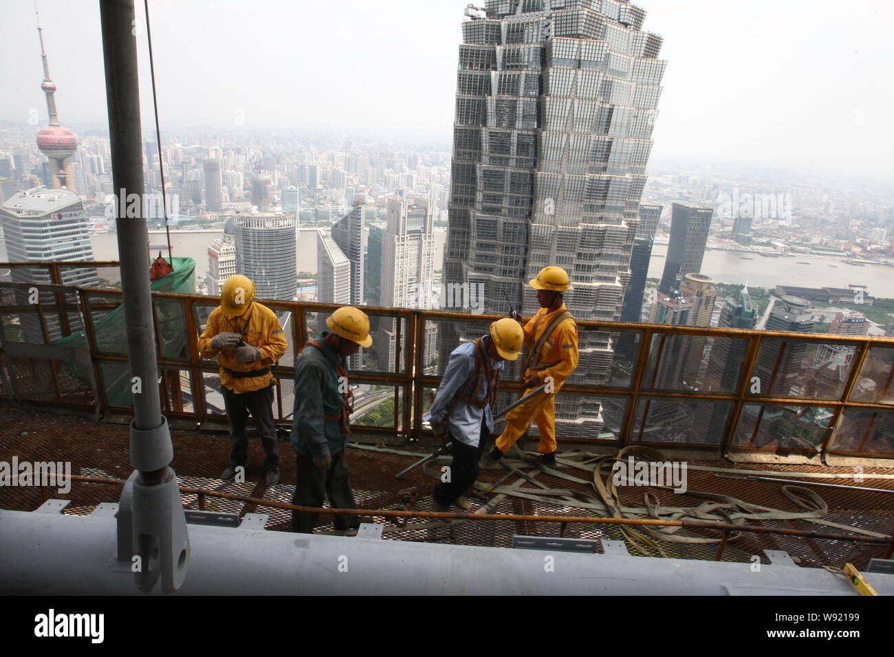 Chinesische Wanderarbeiter schuften auf der 69. Etage des Shanghai Tower im Bau in der Lujiazui Finanzviertel in Pudong, Shanghai, China, Stockfoto