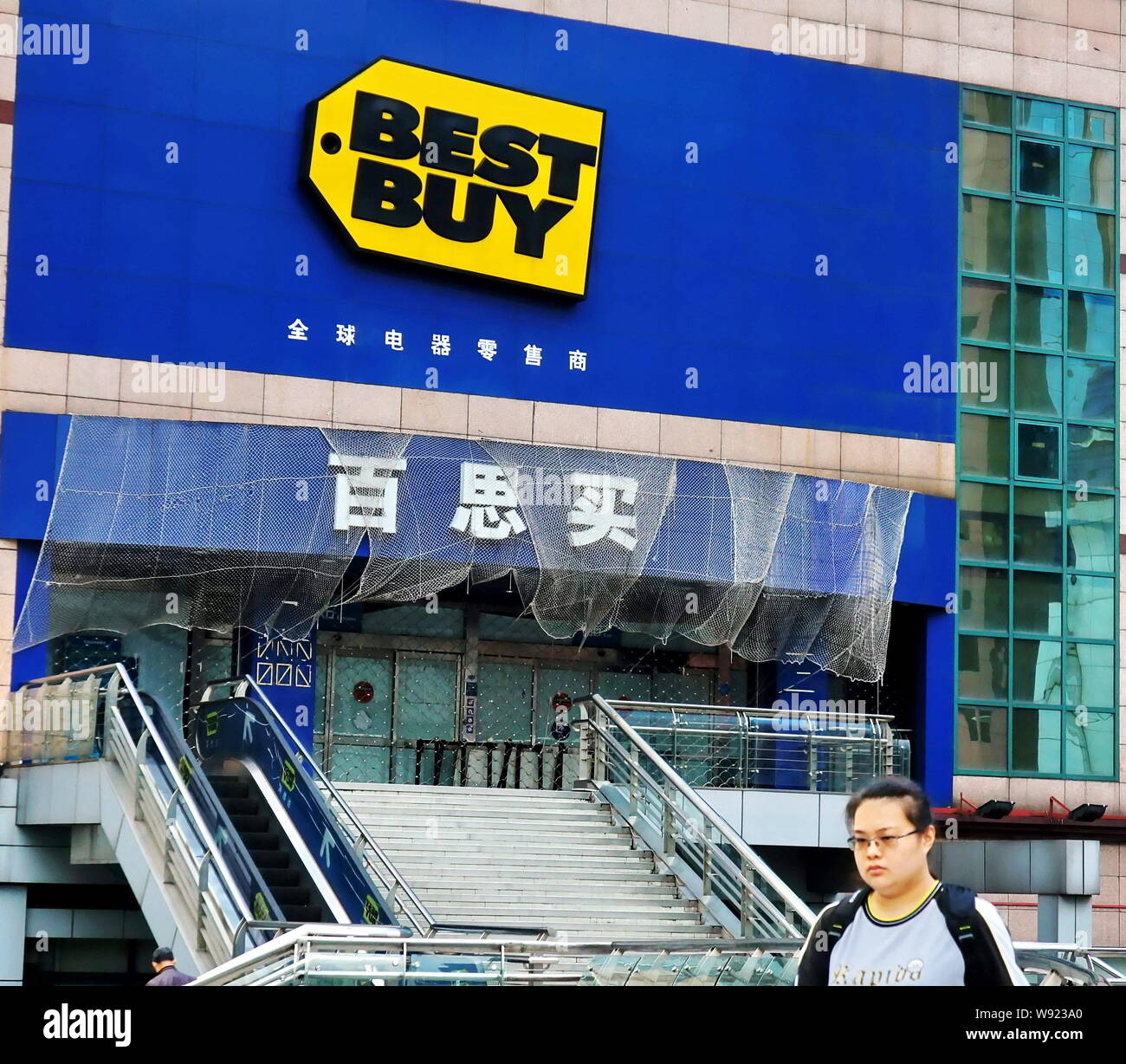 ---- Eine Frau geht an der geschlossenen Best store am Xujiahui shopping Center in Shanghai, China, 9. Mai 2012 kaufen. Am besten kauft bewegen zu verlassen Europa h Stockfoto