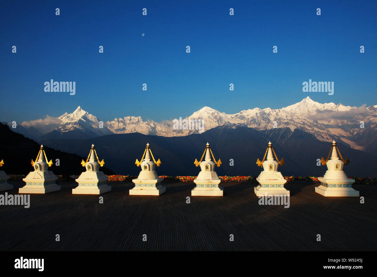 Tibetischen stupas gesehen werden, wenn die ersten Sonnenstrahlen den Kawagebo Peak bei Meili Snow Mountain in Shigatse Grafschaft schlagen, Nordosten China Yunnan Provinz, 3 Stockfoto