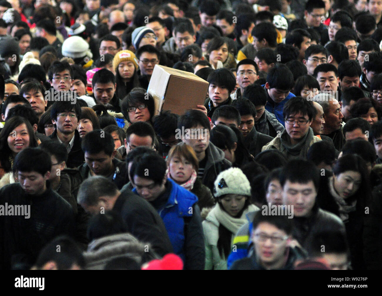 Eine Masse von chinesische Passagiere auf ihrem Weg zurück zum Frühlingsfest oder das Chinesische Neue Jahr warten für Züge an der Qingdao Railway Station in Qing Stockfoto
