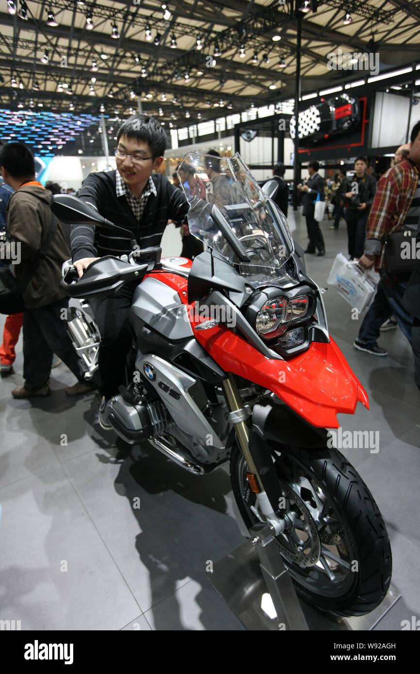 Ein Besucher stellt auf einer BMW R 1200 GS Motorrad während der 15. Internationalen Automobil- Ausstellung in Shanghai, als Auto Shanghai 2013, in Sha bekannt Stockfoto