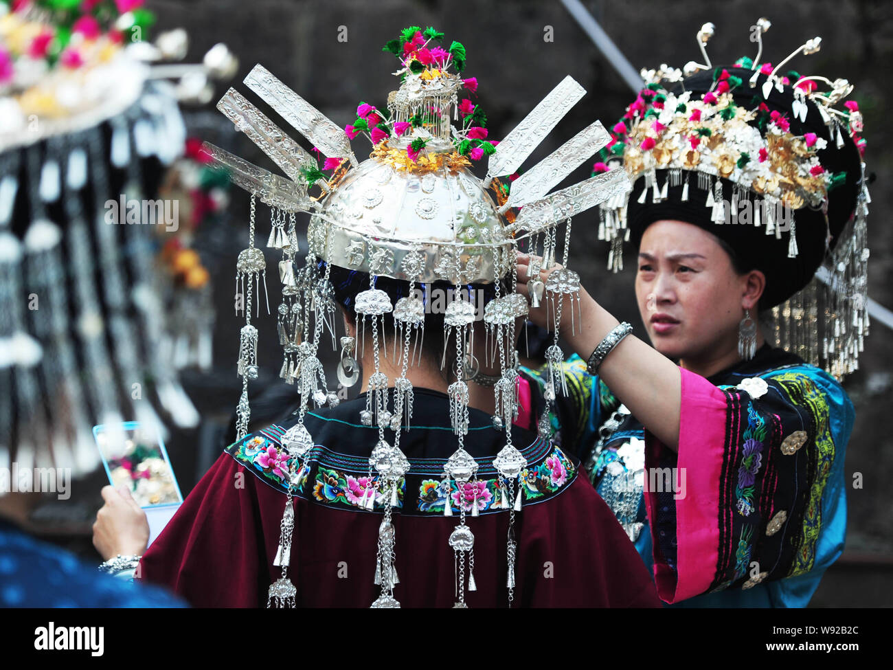 Chinesische Frauen von Miao Miao ethnische Minderheit in traditionellen Kostümen passen ihre Outfits vor der Abschlussveranstaltung ein Kulturfestival auf Stockfoto