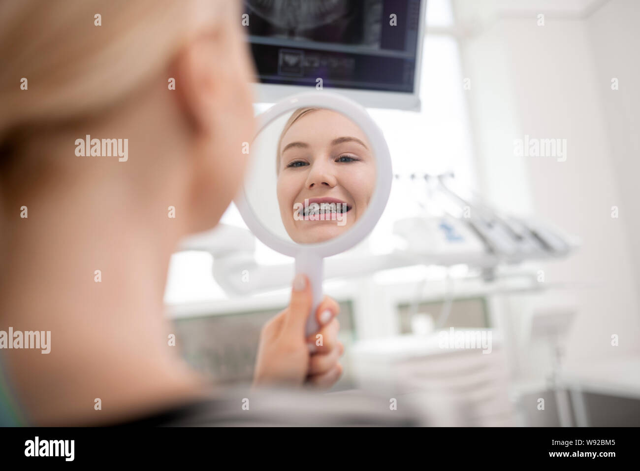 Junge Frau lächelnd in den Spiegel. Stockfoto