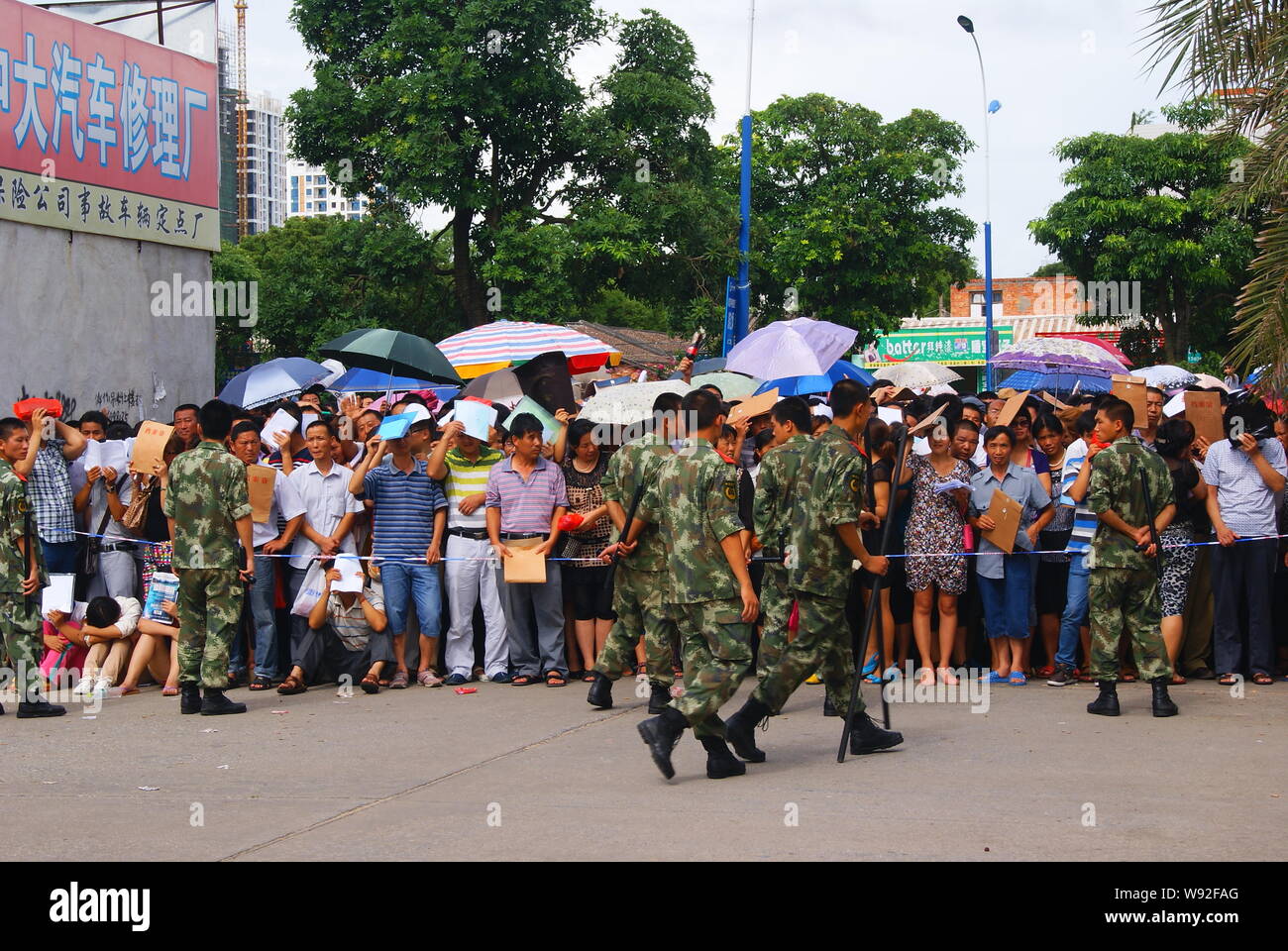 Die chinesischen paramilitärischen Polizisten stehen Wache vor einer Masse von Menschen Schlange, die außerhalb einer Niederlassung der PBOC (Peoples Bank of China), China cent Stockfoto