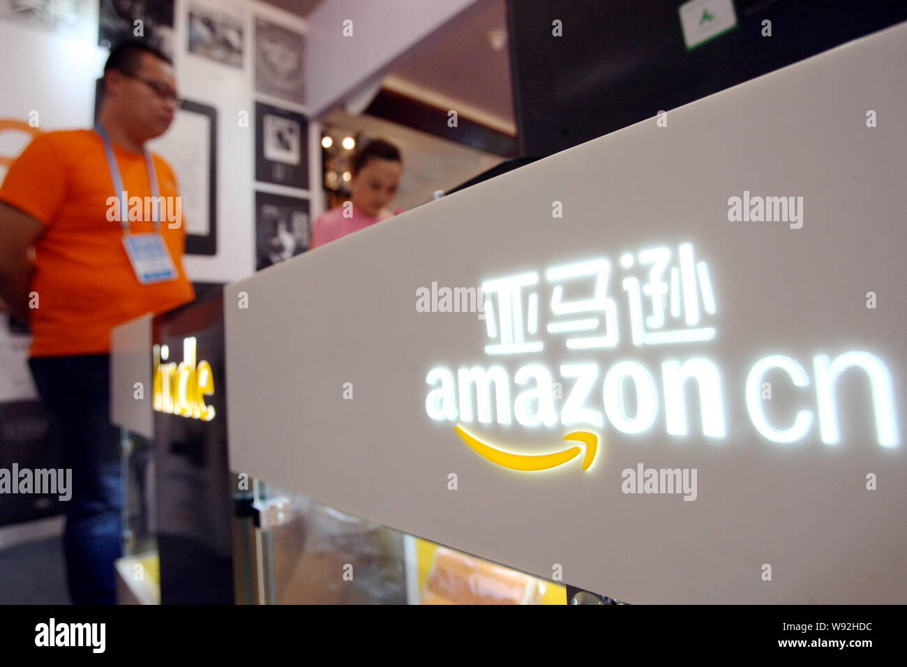 ---- Ein Mitarbeiter ist auf dem Stand von Amazon gesehen. cn während einer Ausstellung in Shanghai, China, 29. August 2013. Amazon.com Inc. ist in der Entwicklung von smartpho Stockfoto