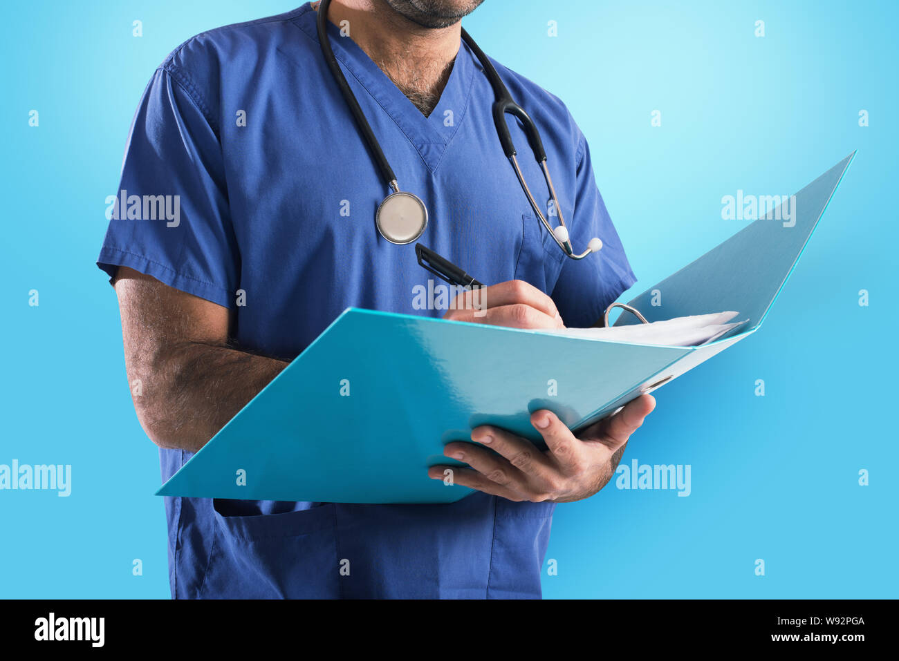 Doktor mit Stethoskop schreibt auf medizinische Aufzeichnung Stockfoto