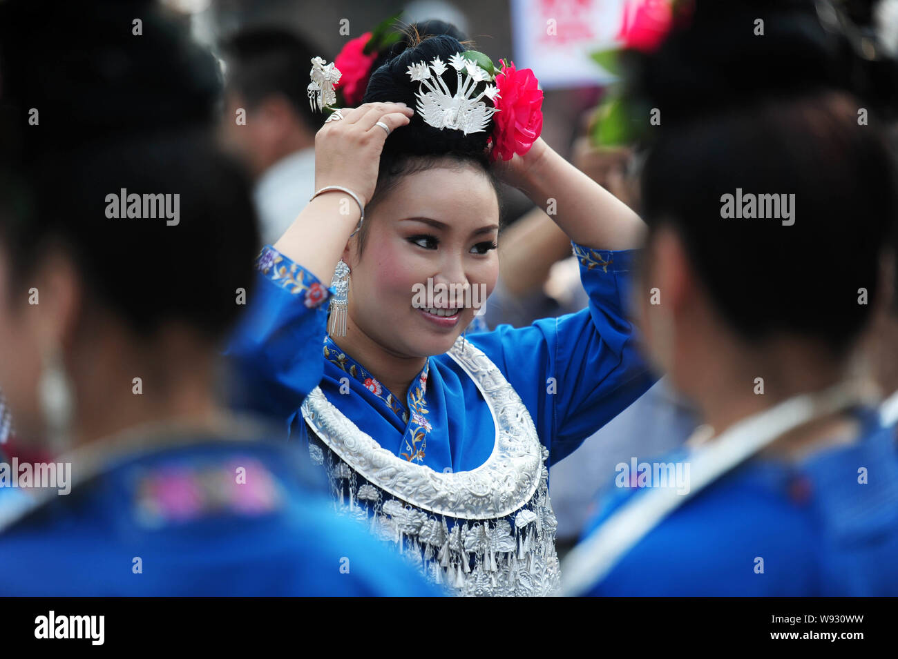 Eine chinesische Frau von Miao, die ethnischen Minderheiten angehören, gekleidet in einem traditionellen Miao Kostüm passt sich Ihren Schmuck vor der Abschlussveranstaltung ein Kulturfestival Stockfoto