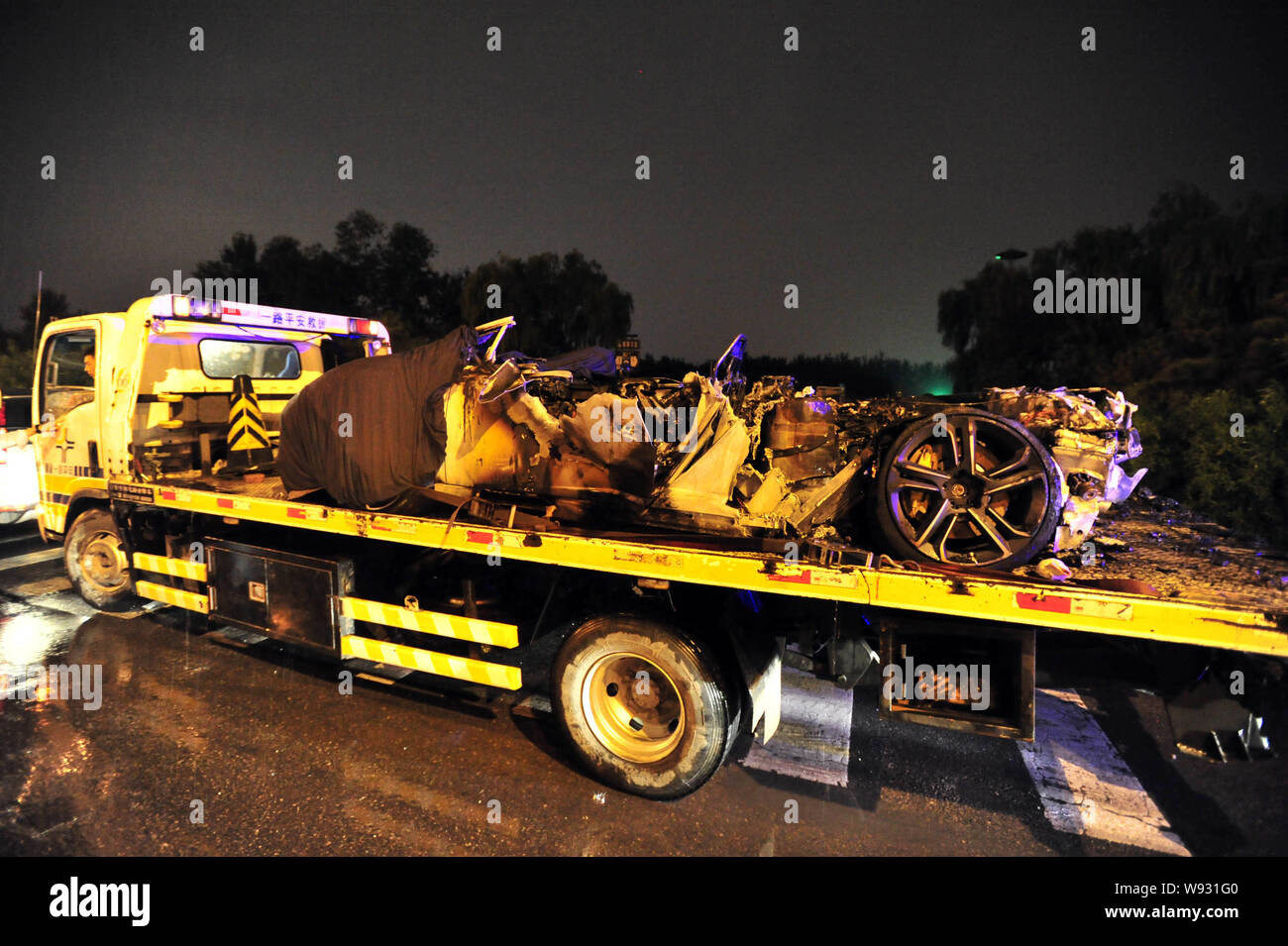 Ein Abschleppwagen mit dem Wrack eines Lamborghini Sportwagen durch Selbstentzündung auf einer Straße in Peking, China, verbrannt, 4. September 2013 geladen. Stockfoto
