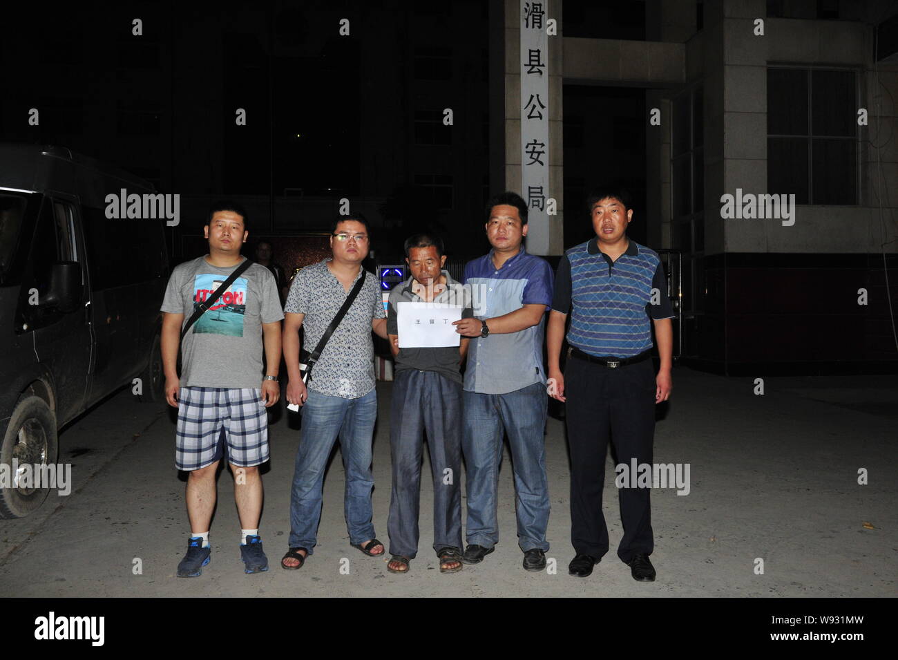 Chinesische Polizisten aus fuping County im Nordwesten von China Shaanxi Provinz halten Baby Menschenhändler Wang Liuding des Babys Menschenhandel Bande in Fron Stockfoto