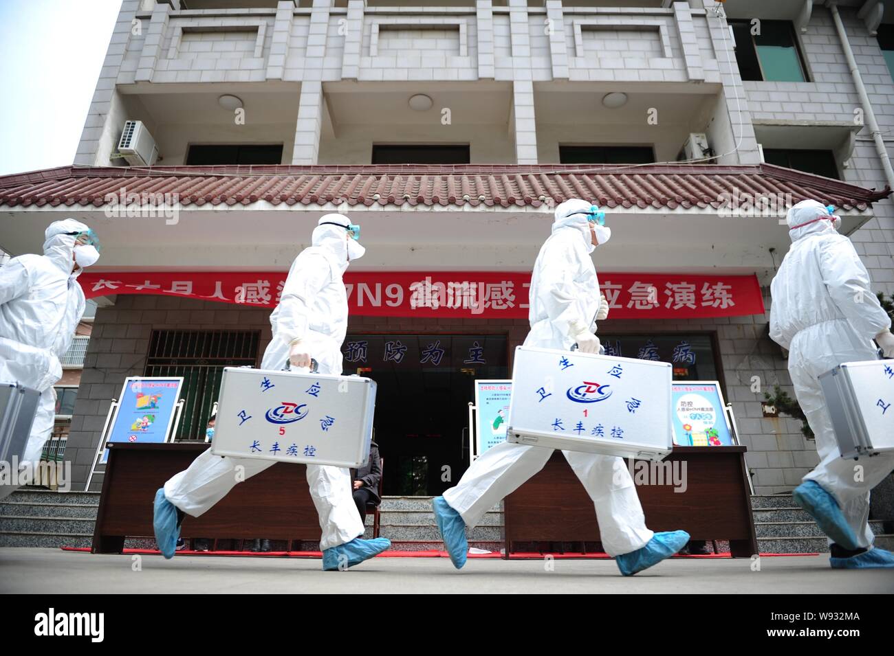 Chinesische Arbeiter aus der lokalen Zentrum für die Prävention und die Kontrolle von Krankheiten, schützende Kleidung, nehmen teil an einem Bohrer gegen das H7N9 Vogelgrippe Stockfoto