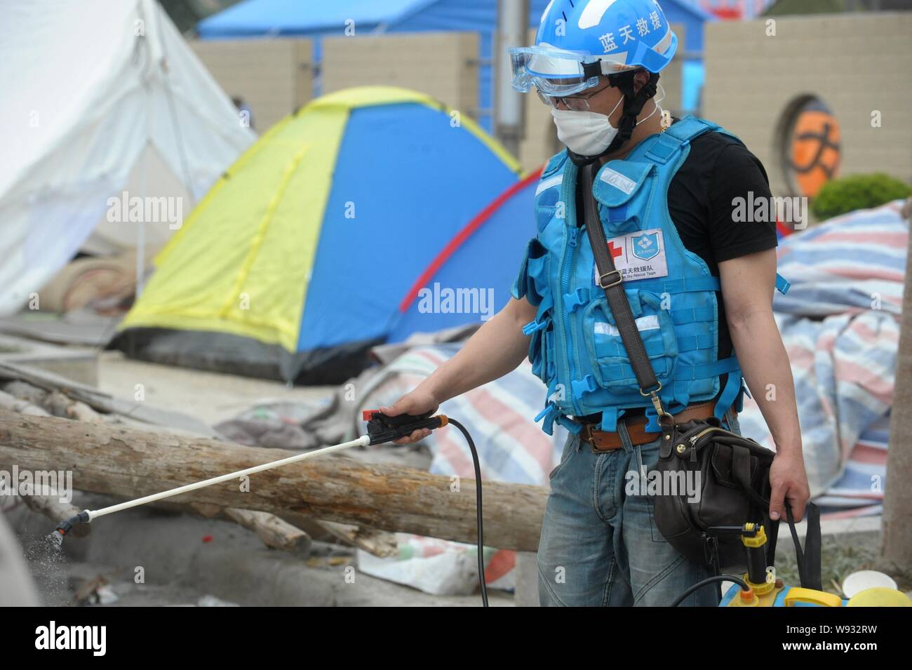 Ein Retter desinfiziert die Trümmer der Häuser durch das Erdbeben der Stärke 7,0 erschüttert - in Lushan County, yaan Stadt, im Südwesten Chinas Provinz Sichuan, 2 Stockfoto