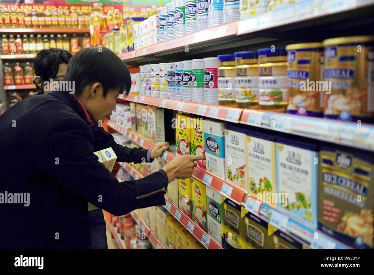 ------ Kunden wählen Milchpulver und Babynahrung in einem Supermarkt in der Stadt Qionghai Dosen, South China Hainan Provinz, am 8. Dezember 2010. In einem Stockfoto