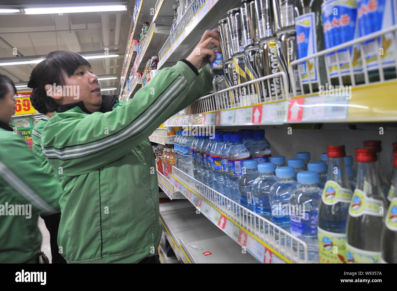 Chinesische Mitarbeiter legen Flaschen Mineralwasser auf dem Regal für Verkauf in einem Supermarkt nach dem Zhuozhang Fluss war verunreinigt durch Anilin durch eine ch ausgelaufen Stockfoto
