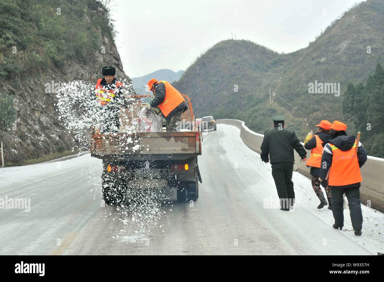 Arbeiter auf einem Lkw spray Salz, Eis auf dem hügeligen Straße in der Nähe von Kaili Stadt zu reinigen, im Südwesten Chinas Provinz Guizhou, 4. Januar 2013. China ist Erfah Stockfoto