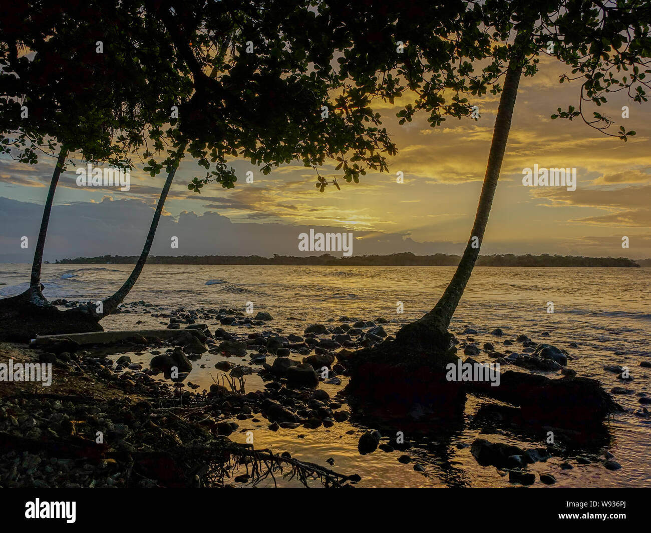 Insel Bastimentos, Bocas del Toro, Panama - 18. März 2017: Sonnenuntergang am Strand mit der Sonne unter Palmen mit Bastimentos Island in der b Stockfoto