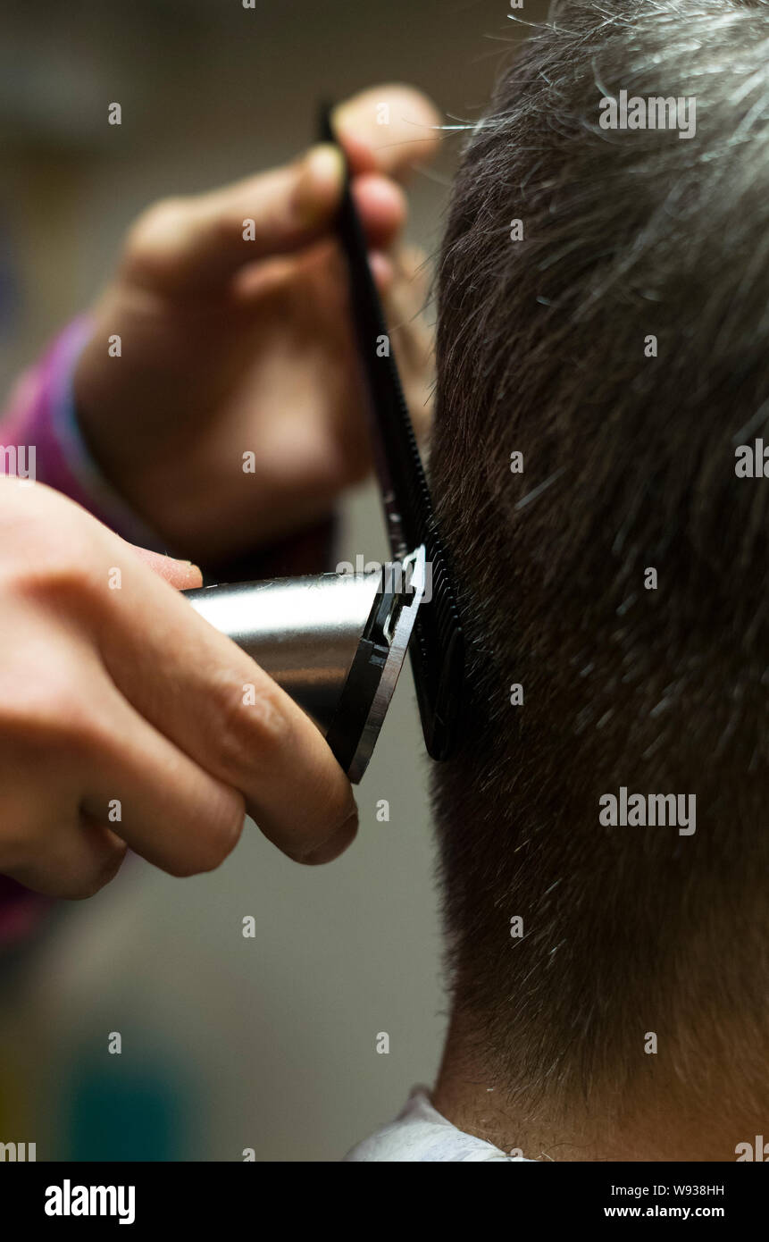 Friseur schneiden Mans grau Hören mit Clipper, Hände, Nahaufnahme Stockfoto