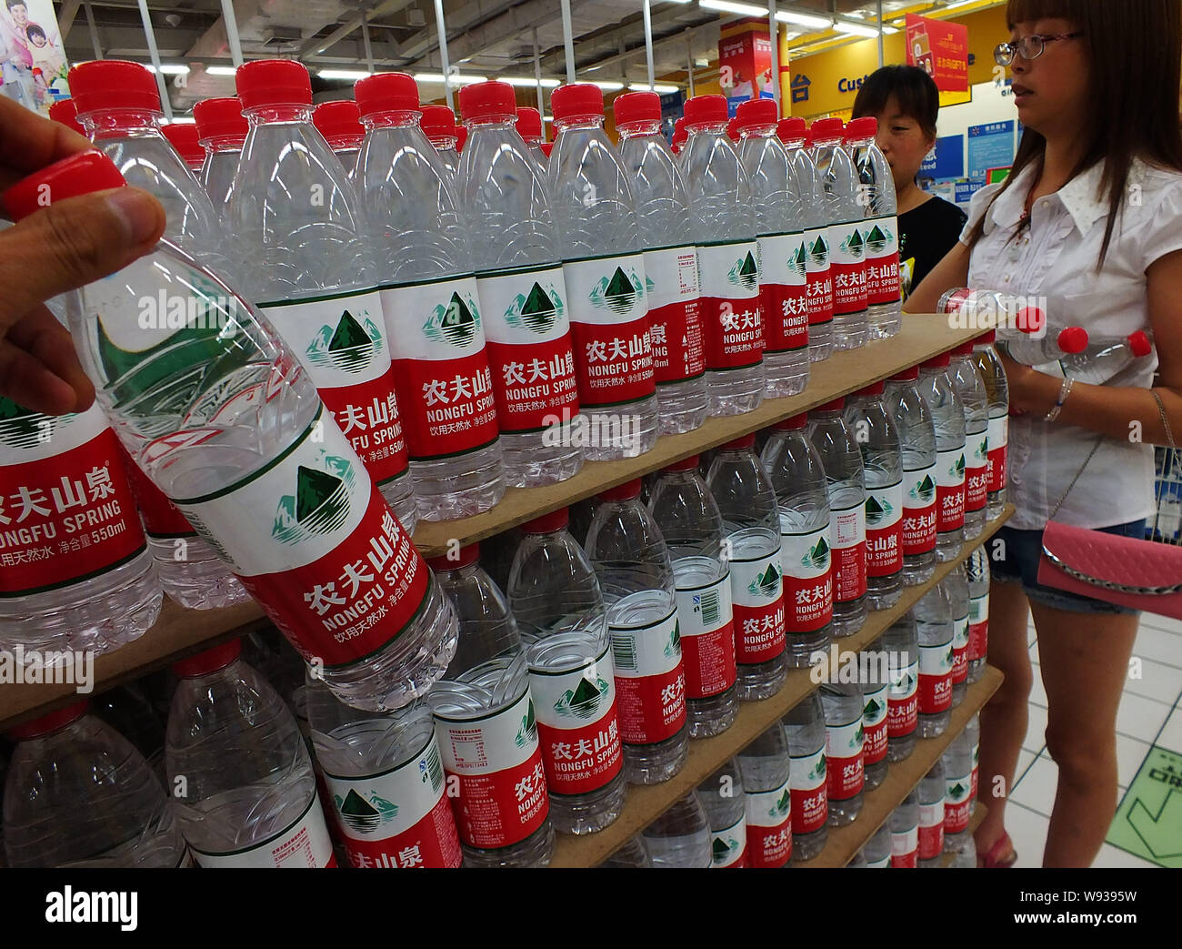 ------ Chinesische Kunden kaufen Flaschen Nongfu Quellwasser in einem Supermarkt in Kunshan, China Provinz Hubei, 6. Mai 2013. Nongfu Feder, Stockfoto