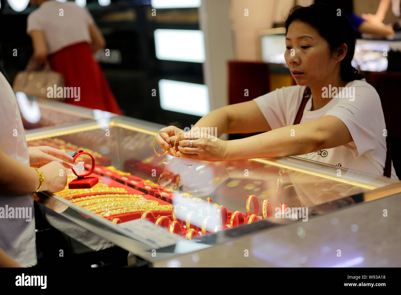 Ein chinesischer Kunde kauft gold Ornamente in Gold shop in Wuhan City, Central China Provinz Hubei, 28. Juni 2013. Als global gold Preise am Freitag (2. Stockfoto