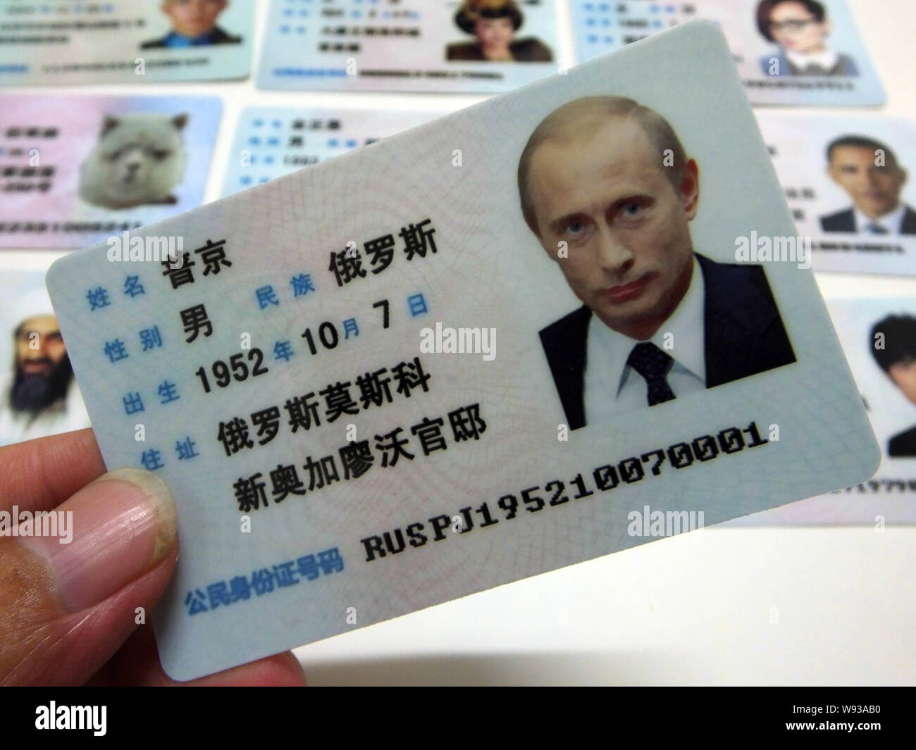 Ein Mann zeigt eine gefälschte Chinesischen ID-Karte des russischen Präsidenten Wladimir Putin zum Verkauf an einen Stand auf einer Straße in Guangzhou City, South China Guangdong provi Stockfoto