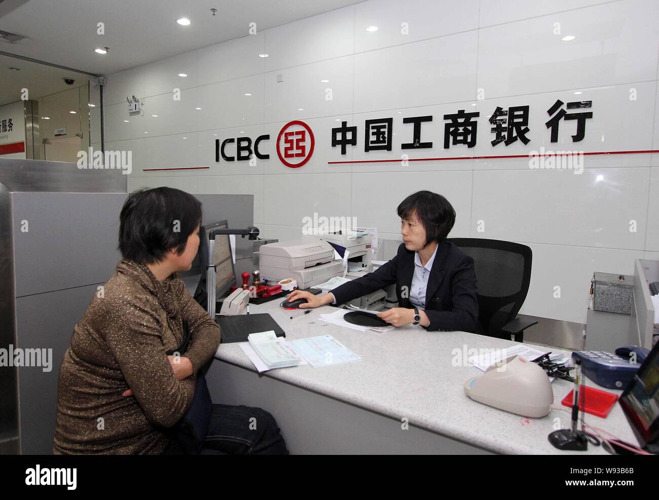 ---- Eine chinesische Angestellte dient ein Kunde an einem Zweig der ICBC (Industrielle und kommerzielle Bank von China) in Jinjiang city, südost China Fujian prov Stockfoto